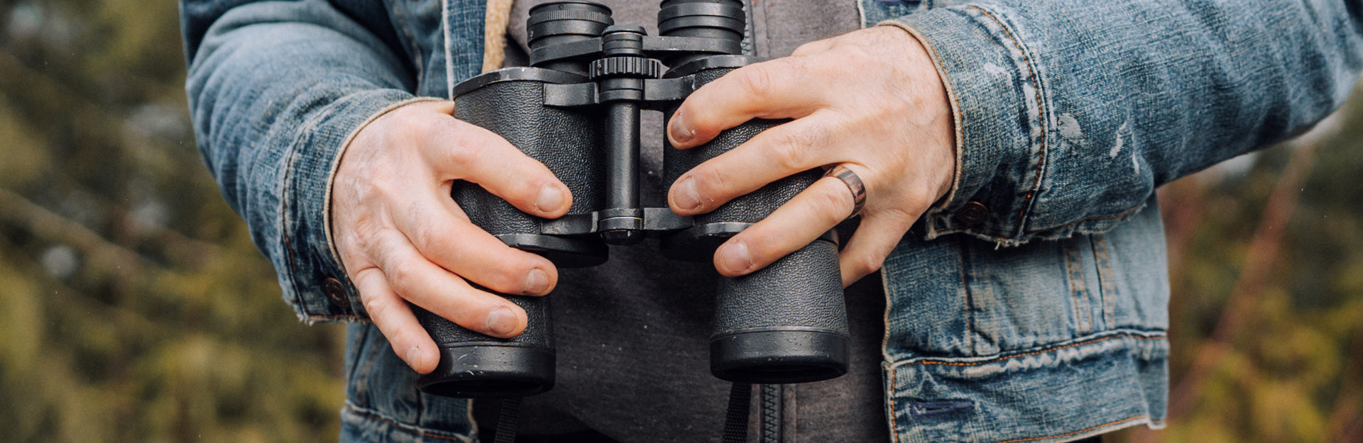 man holding binoculars wearing a groove ring