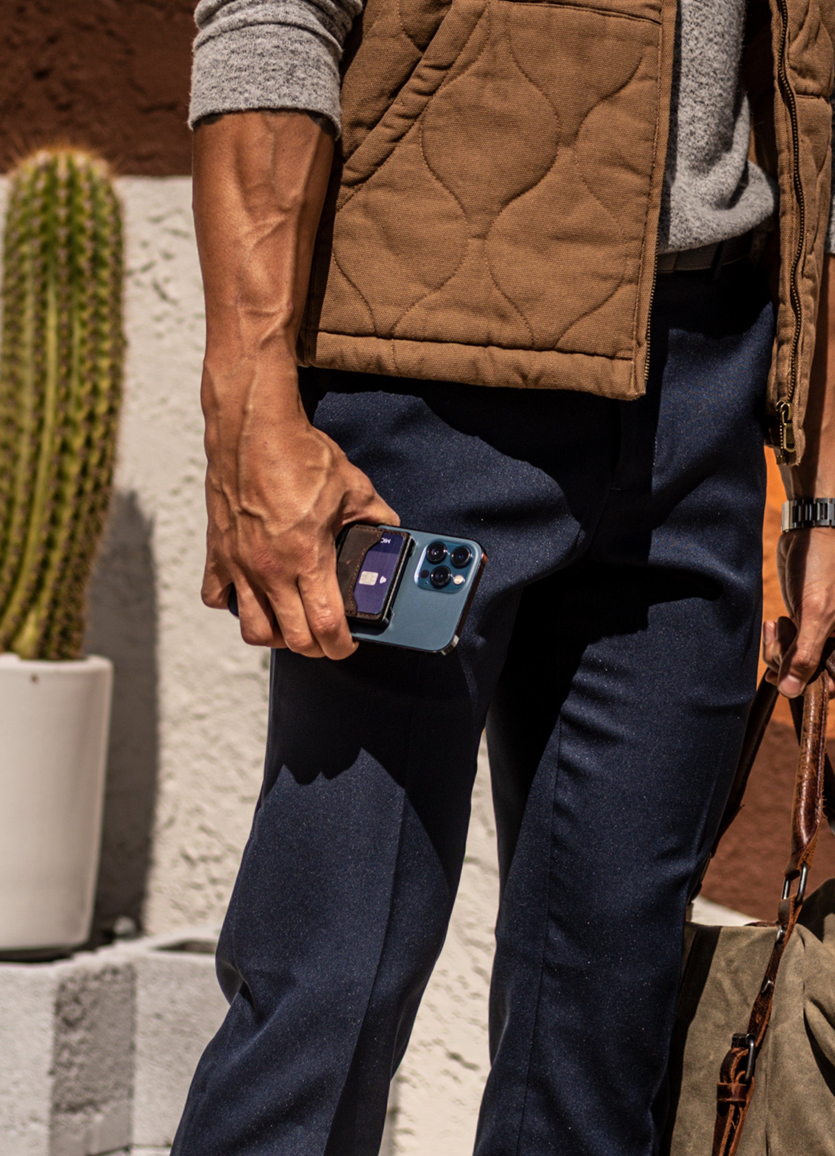 man standing holding an iPhone with a Groove Wallet Go attached