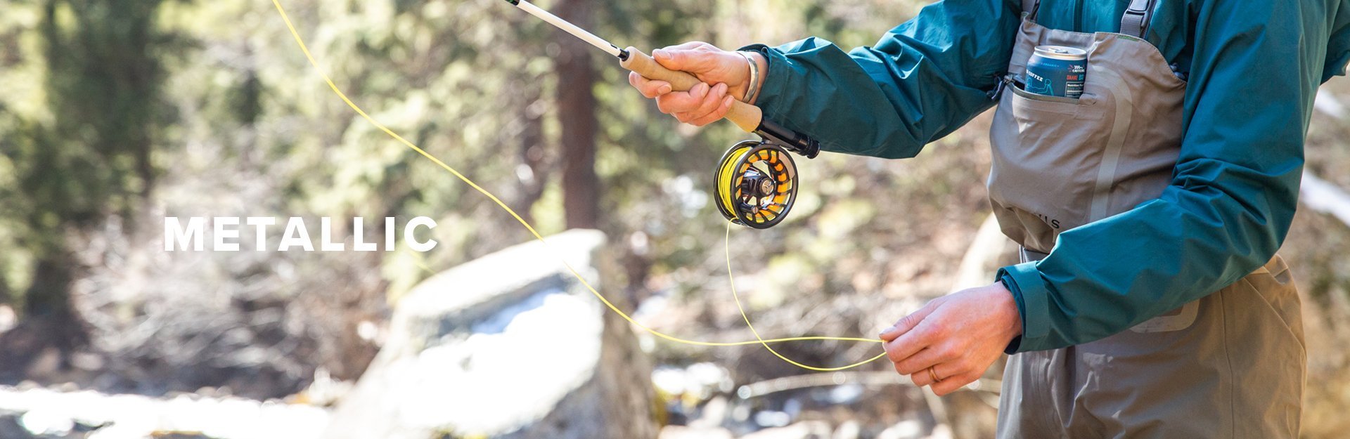 Metallic, a woman fly fishes in a stream