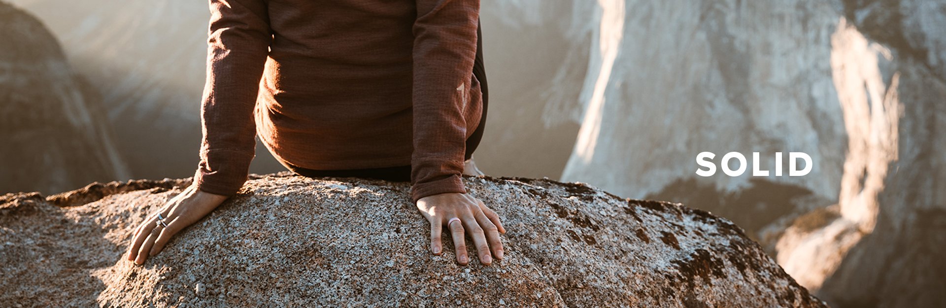 Solid, person sitting on a large boulder