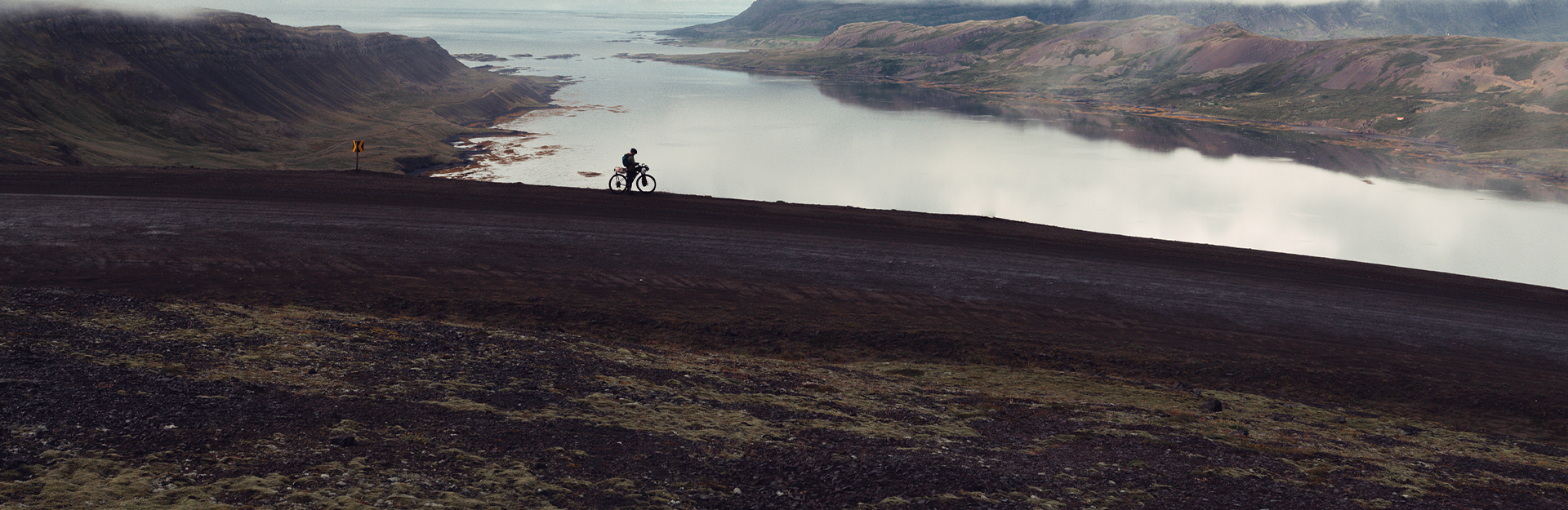 Guy biking next to a fjord