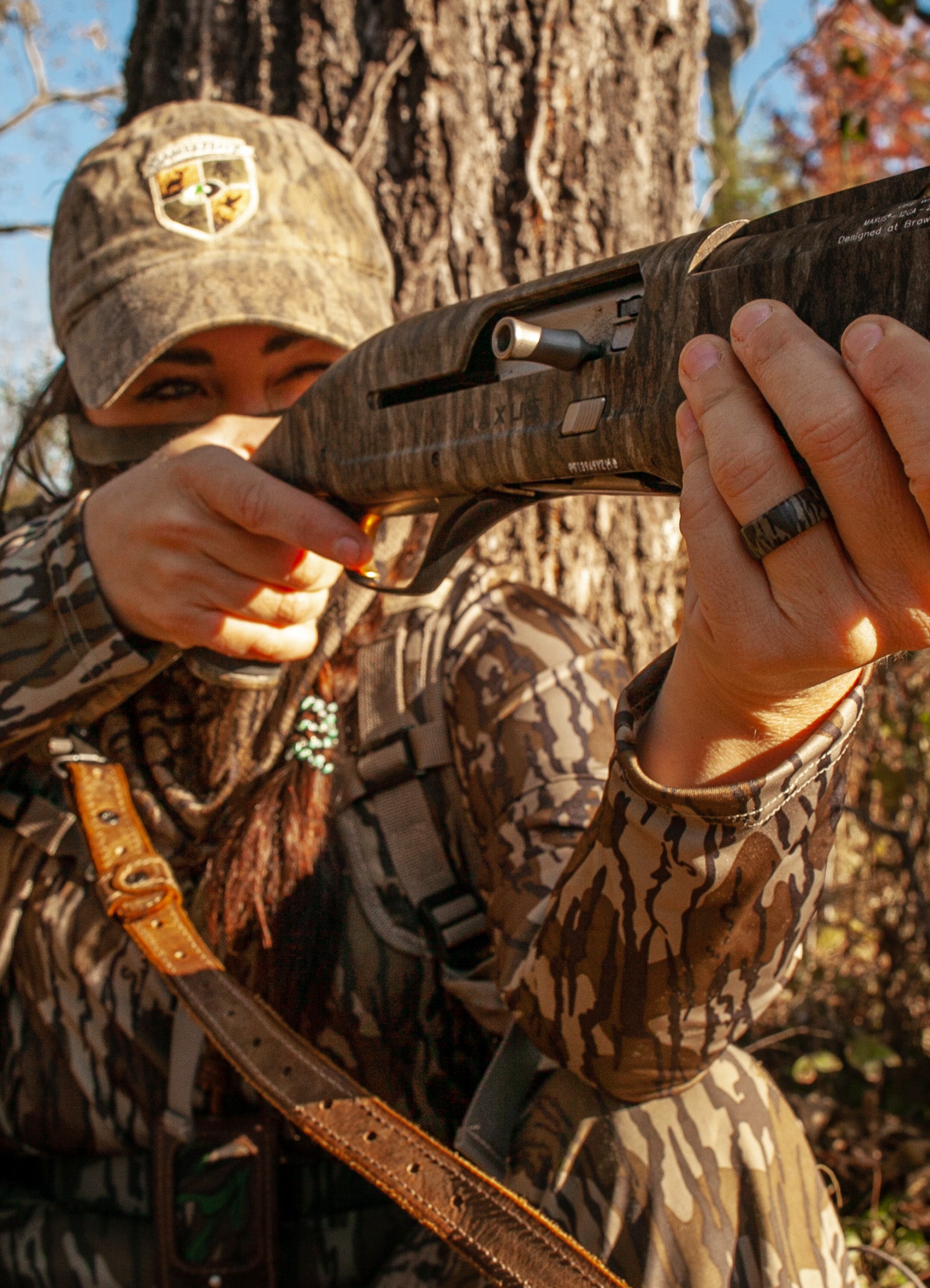 woman holding a hunting rifle wearing Groove Life camo rings