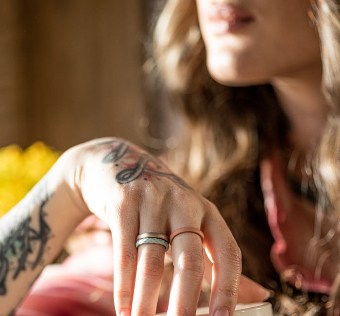 image of a woman's hand holding a coffee cup wearing Groove Life stackable rings