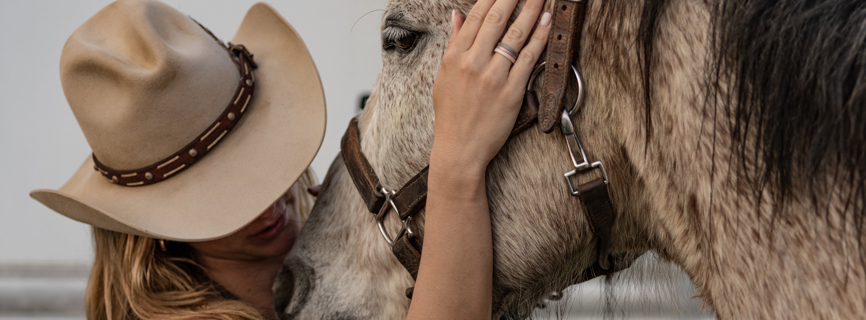 woman petting a horse wearing Groove Life stackable rings