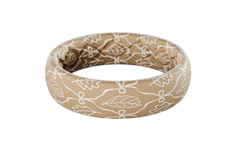 Beige silicone ring with white floral pattern on a white background