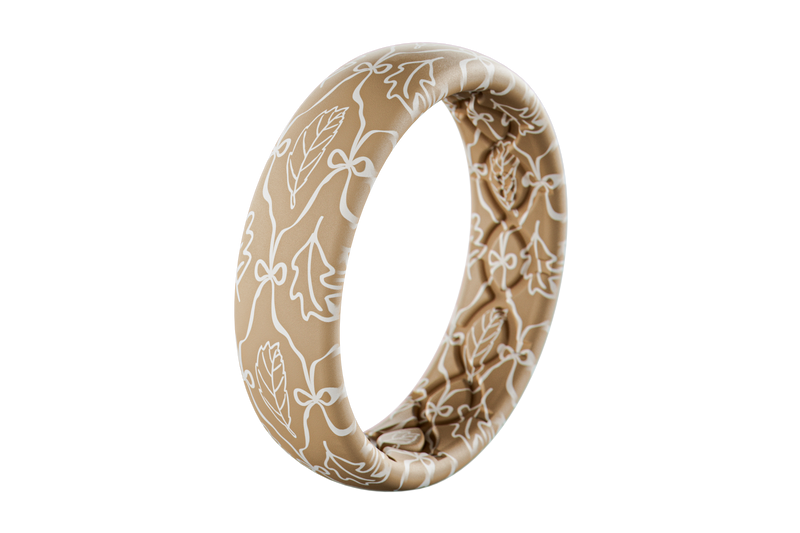 Beige silicone ring with white floral pattern on a white background