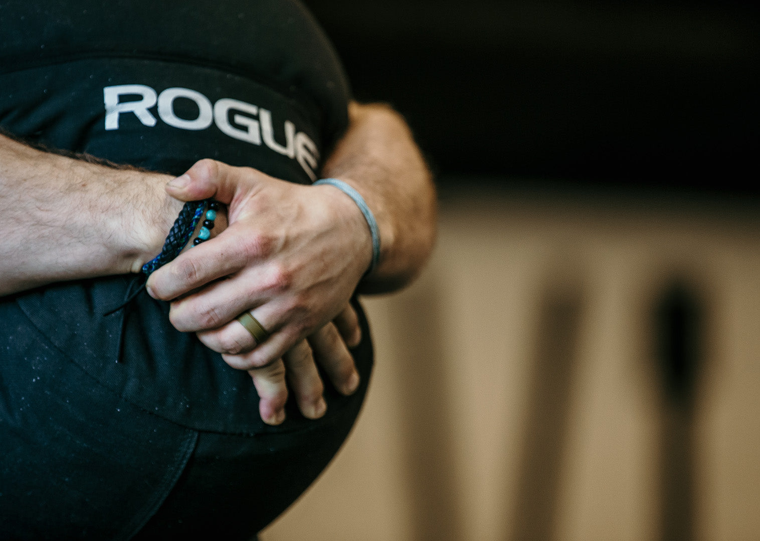 man holding a Rogue fitness ball wearing Groove Life rings