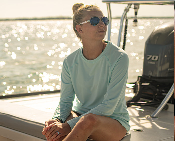woman sitting on a boat wearing Groove Life Guy Harvey rings