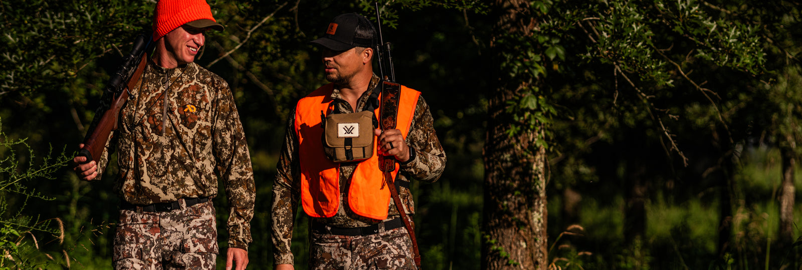two men walking outdoors wearing camo and Groove Life + MeatEater collab rings and belts