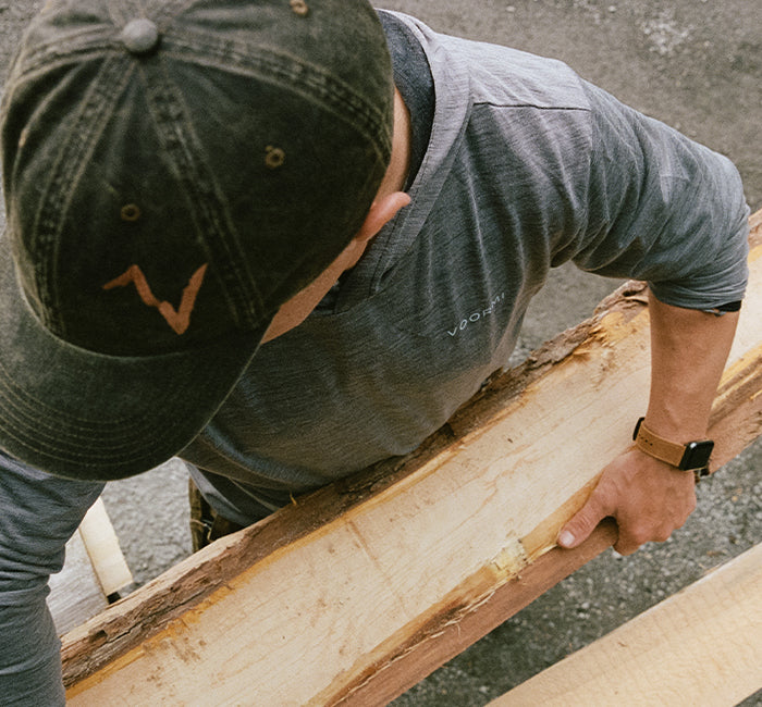 man carrying a plank of wood wearing a Groove Life watch band