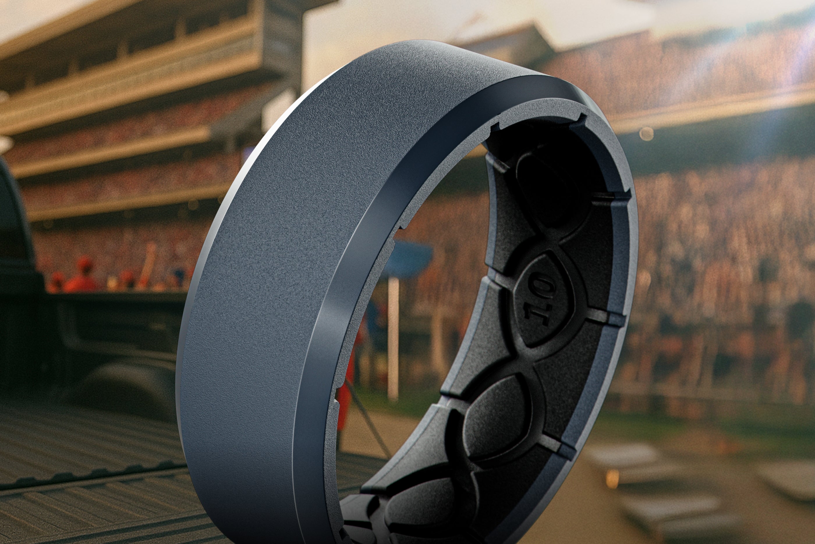 Close-up of a car wheel with a blurred stadium background