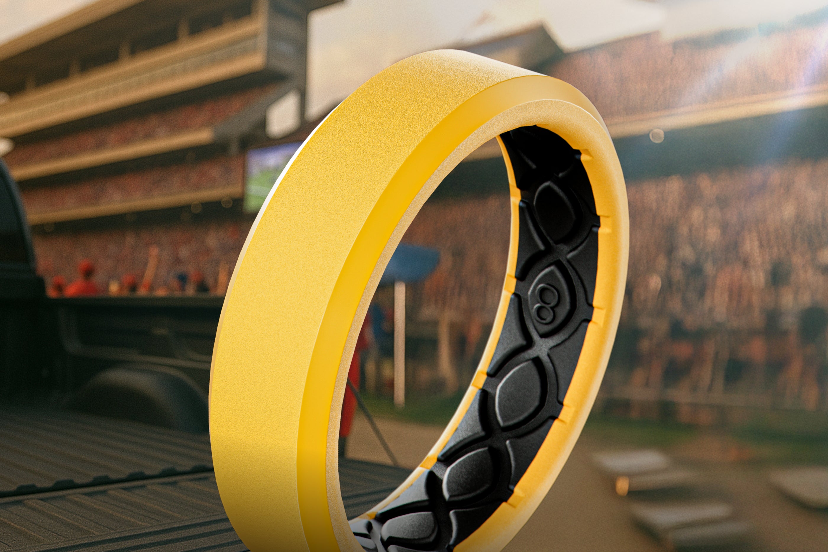 Close-up of a yellow and black ring with a stadium in the background