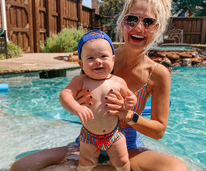Amber Massey holds up her baby son in a pool