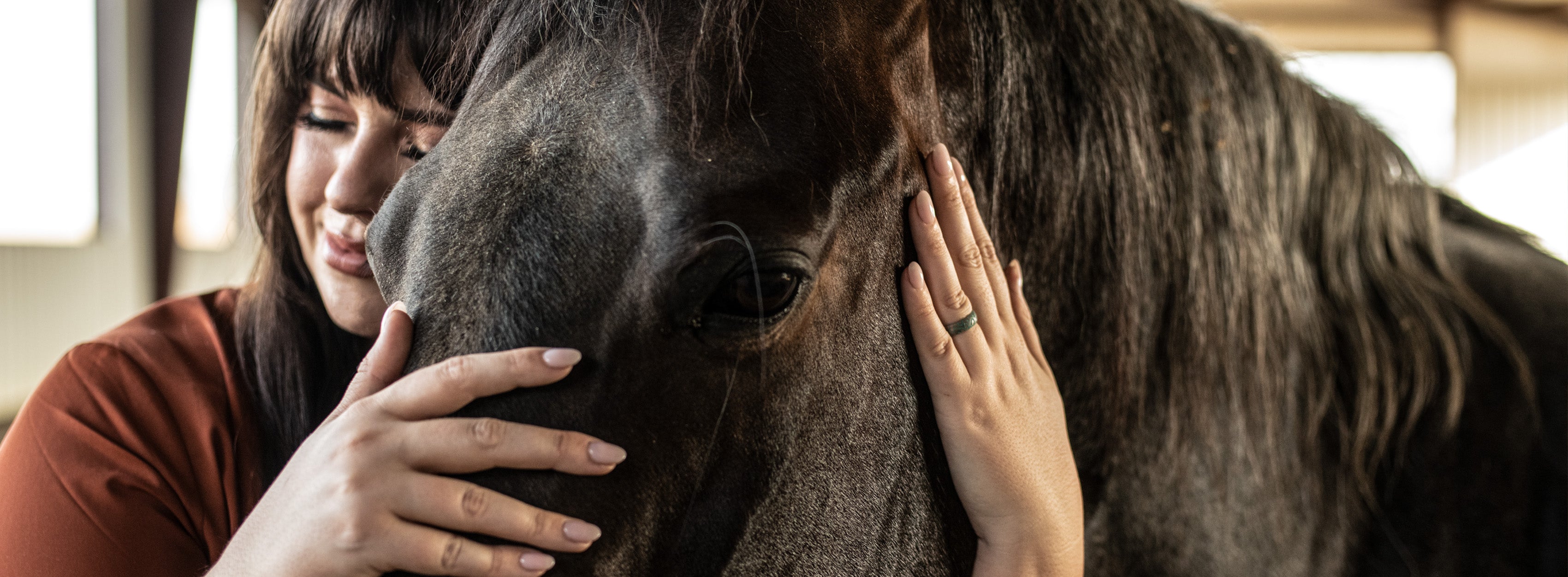 Katie Van Slyke hugging a horse wearing a Groove Life ring