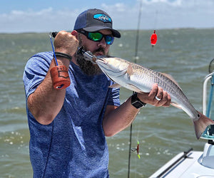 Jeremiah Doughty kisses a large saltwater fish he recently caught