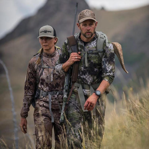 two hunters dressed in Kryptek gear, hike back after a successful hunt