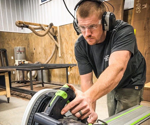 Dustin Payne uses a circular saw to make cuts in wood in his woodshop